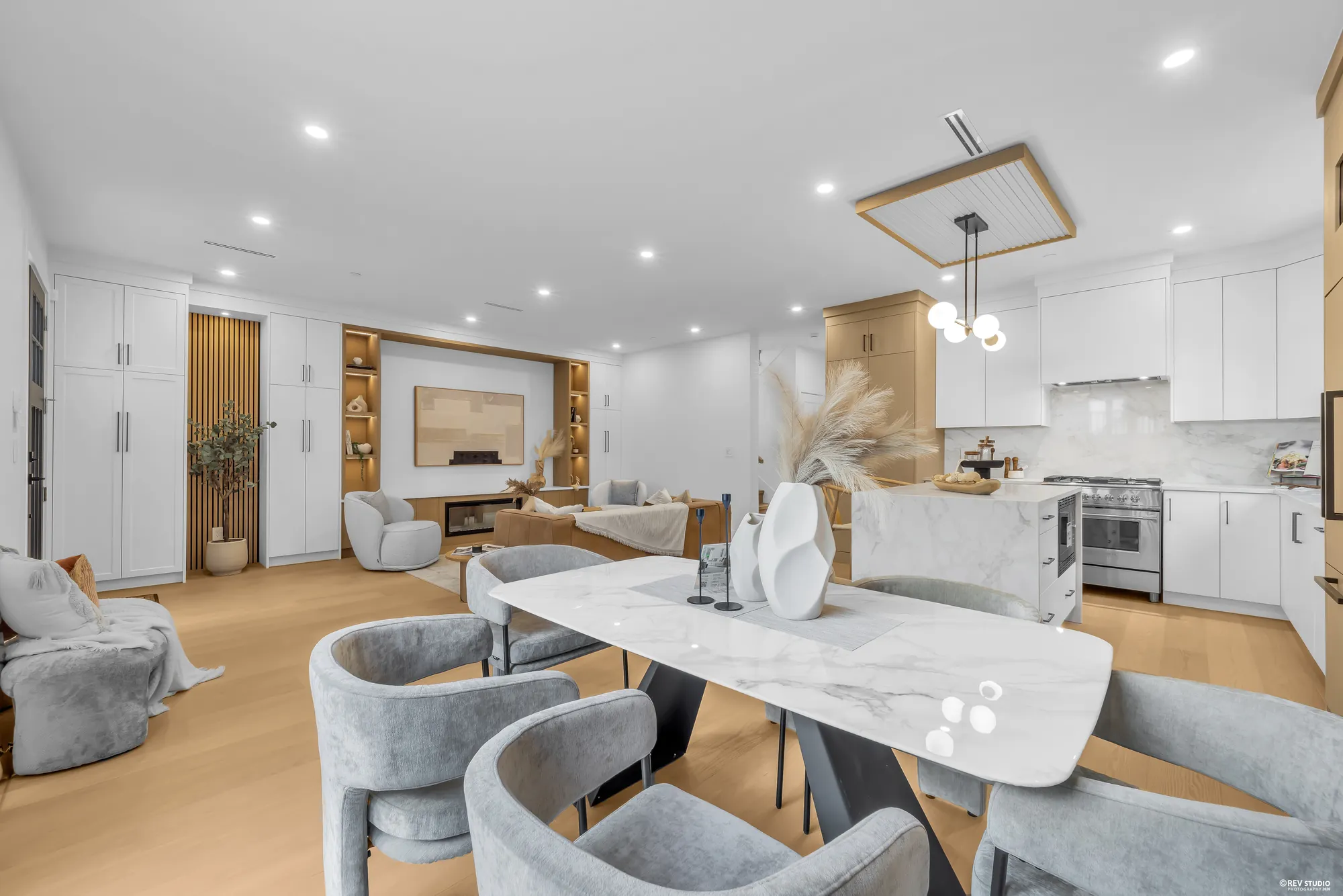 Dining table between the living room and the kitchen island