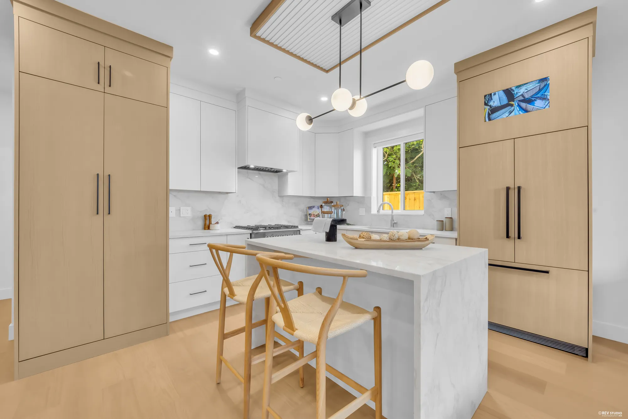 Kitchen island with seating, integrated fridge behind