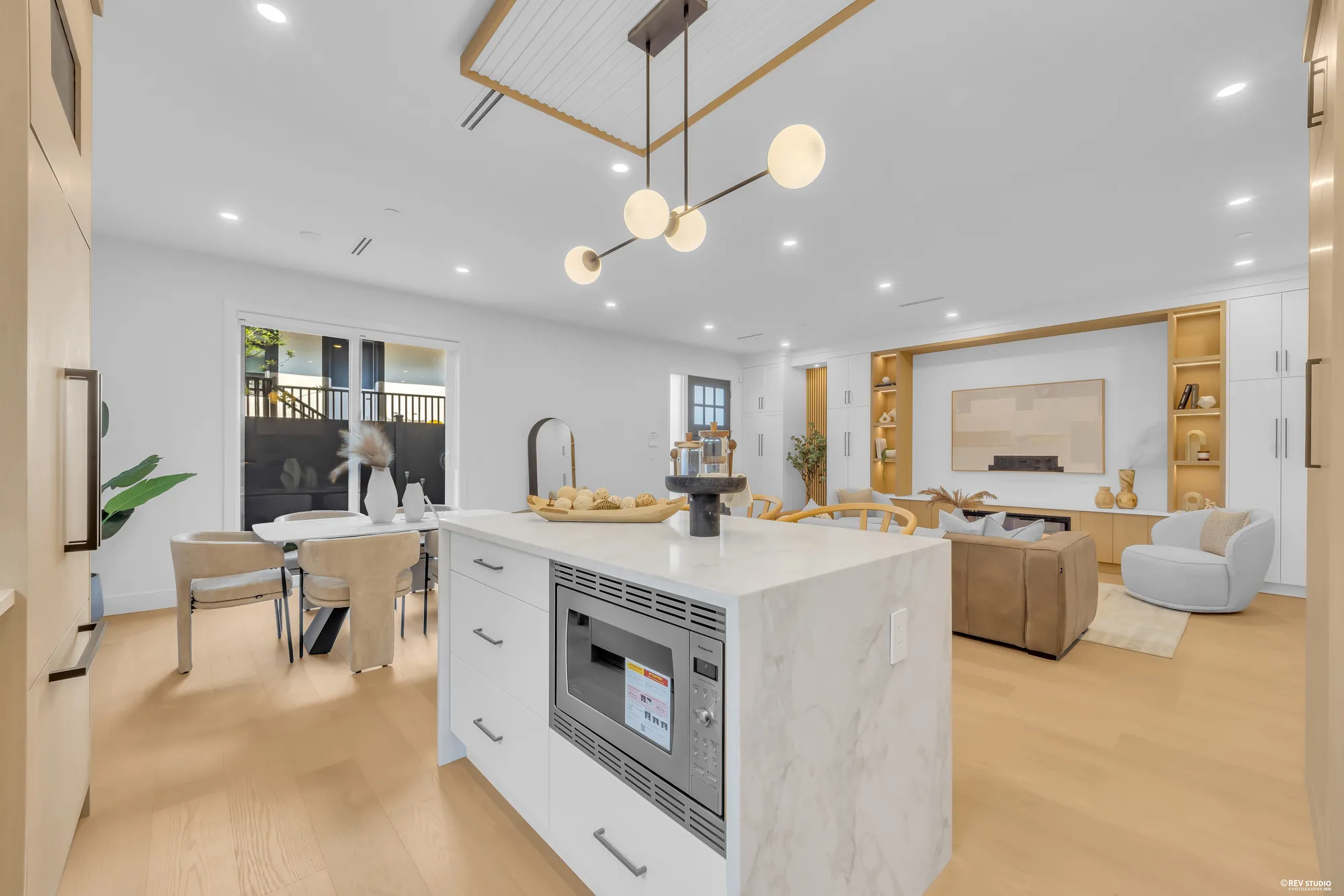 Kitchen and dining from the living room, pendant lights over the island