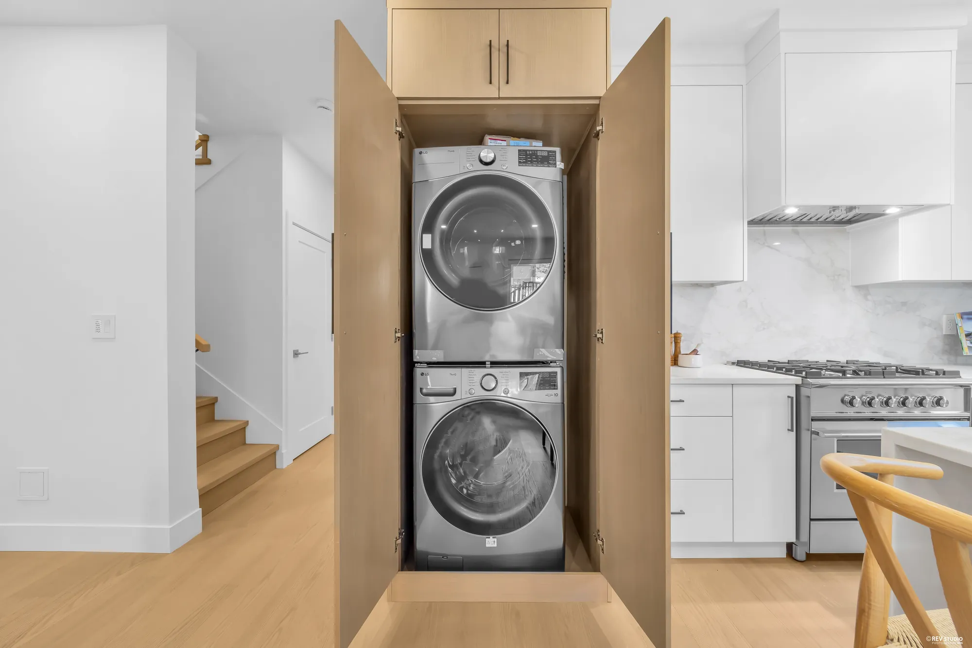 Stacked washer and dryer in a cabinet off the hall